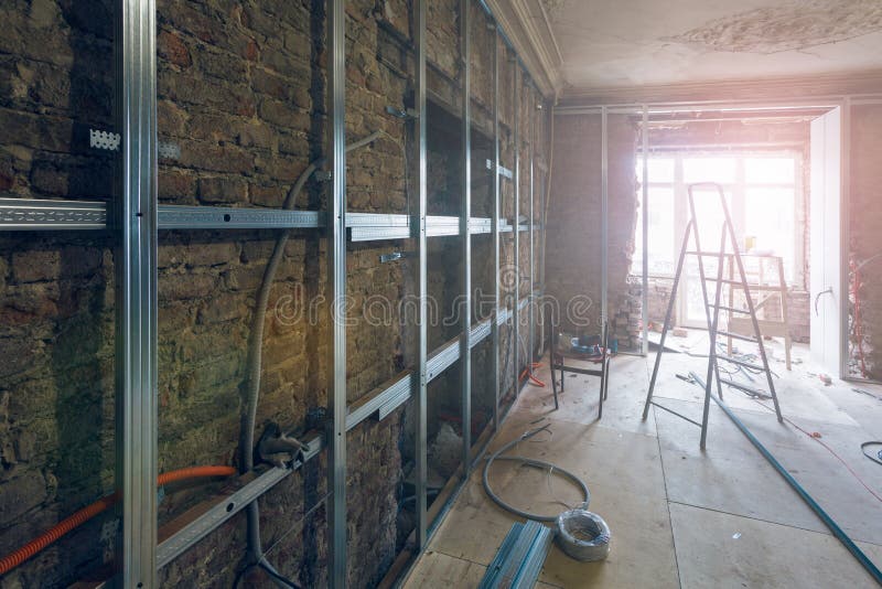 Lavoro trattato di installazione delle strutture del metallo per il muro a secco del pannello di carta e gesso per la fabbricazio immagini stock Lavoro trattato di installazione delle strutture del metallo per il muro a secco del pannello di carta e gesso per la fabbricazio immagini stock