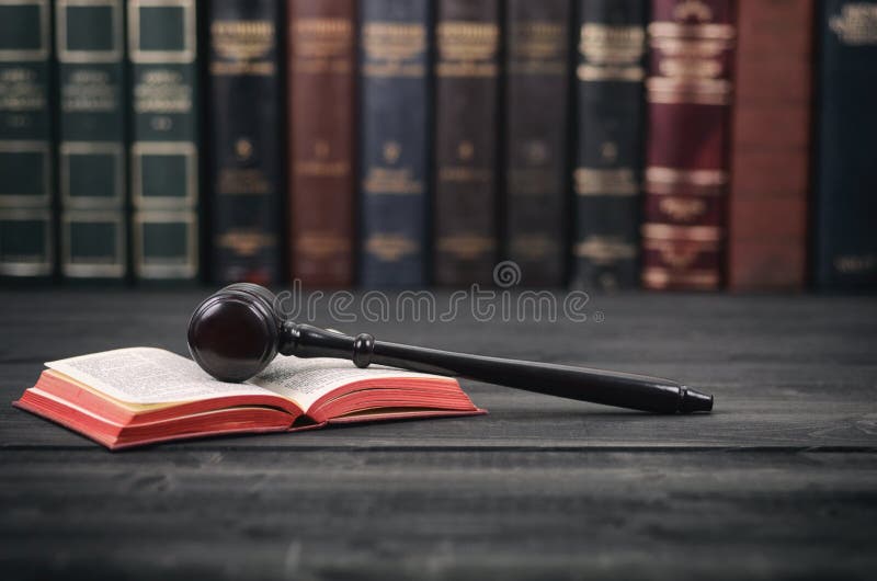 Judge Gavel and law book on a black wooden background.