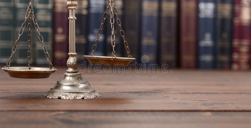 Scales of Justice and Law books on a  wooden background