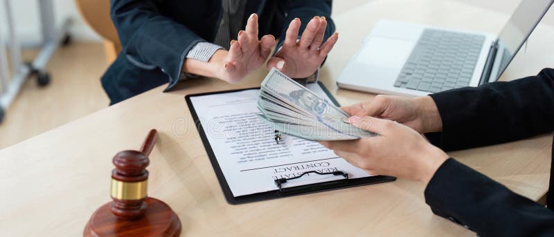 Avocat care acceptă mită pentru corupție în cadrul biroului, cu contract și ciocănel pe birou. Un avocat care acceptă mită într-un birou care pune în evidență teme legate de corupție și comportament lipsit de etică.