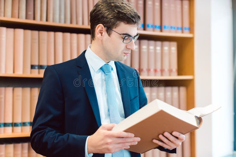 Lawyer in His Office Reading Precedents in Thick Books Stock Photo