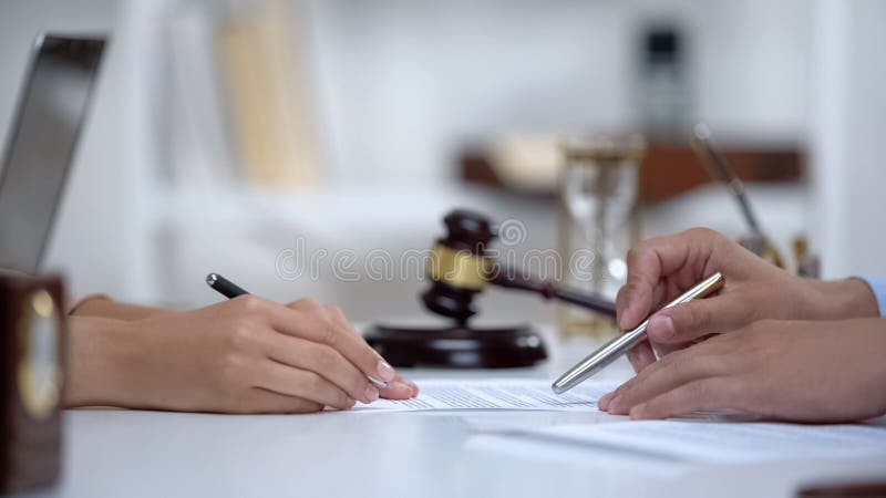 Lawyer showing woman where to sign court claim, professional help to plaintiff stock images Lawyer showing woman where to sign court claim, professional help to plaintiff stock images