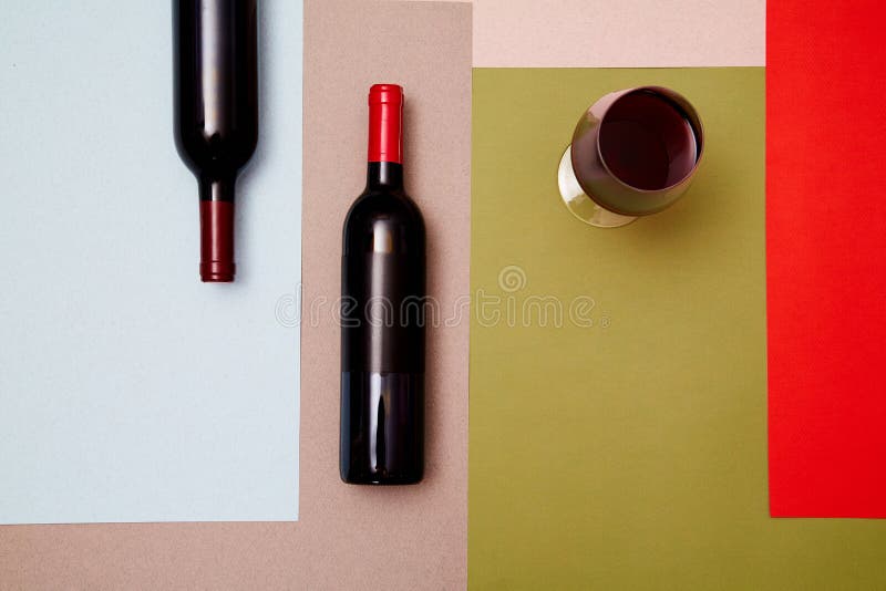 Lay-out van flessen en glas rode wijn op kleurrijke document achtergrond stock foto's Lay-out van flessen en glas rode wijn op kleurrijke document achtergrond stock foto's