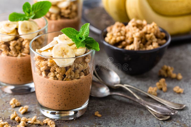 Layered chocolate chia pudding parfait with banana, granola and yogurt, dessert royalty free stock photo Layered chocolate chia pudding parfait with banana, granola and yogurt, dessert royalty free stock photo