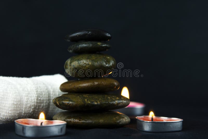 Layers of Hot Stones Use for Massage Setting Lit by Candles Light and