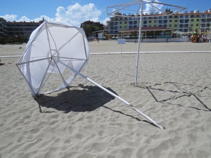 Laying Destroyed White Sand Beach Parasol Umbrella in Wind Protecting from Sun During Exotic Vacation, Tsarevo, Serenity Bay, Bulg royalty free stock photos Laying Destroyed White Sand Beach Parasol Umbrella in Wind Protecting from Sun During Exotic Vacation, Tsarevo, Serenity Bay, Bulg royalty free stock photos