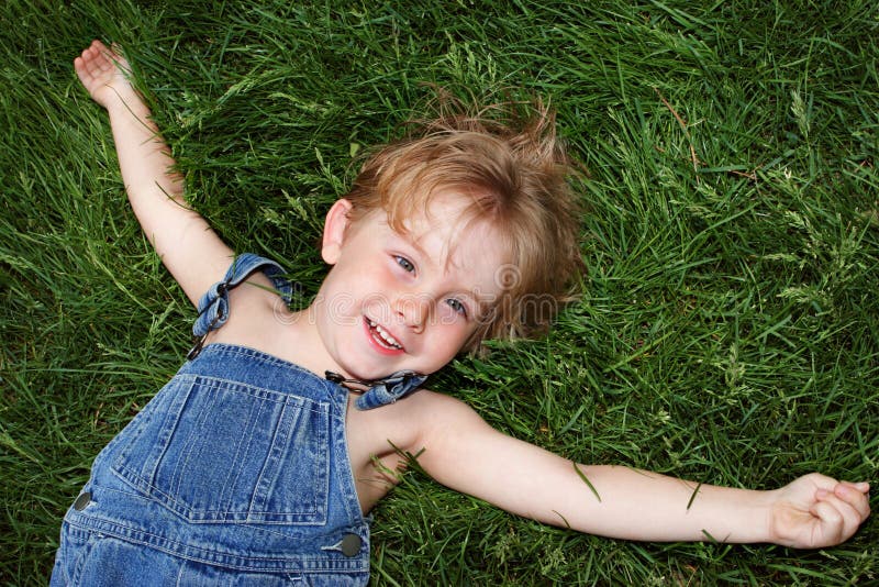 Laying in the grass stock image. Image of preschooler - 2623095