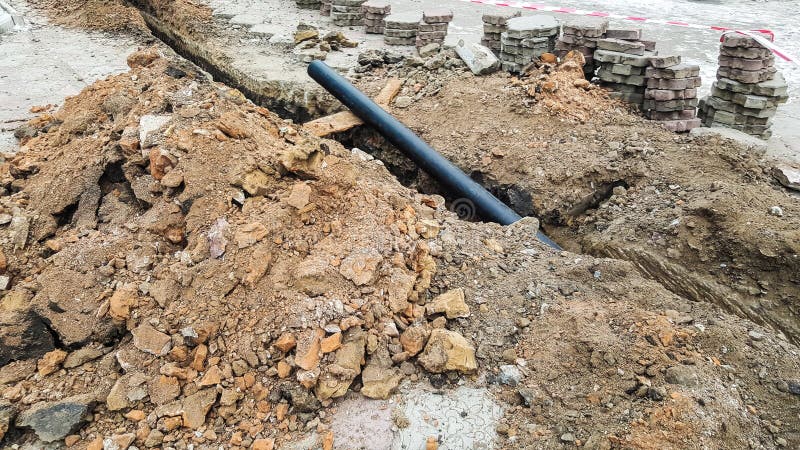 Laying Installation of a New Cable in a Plastic Pipe. Digging Drilling ...