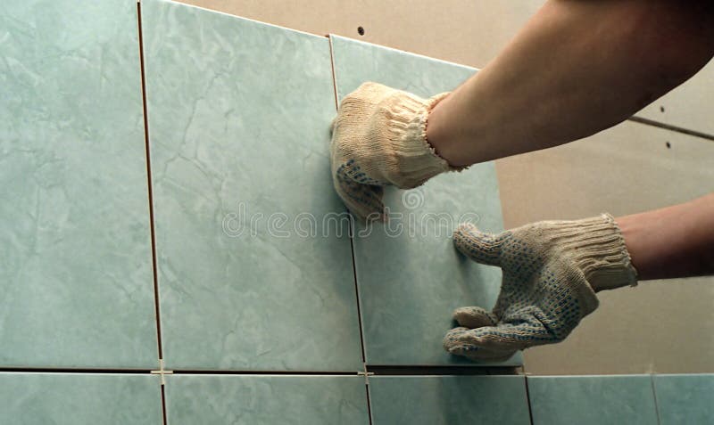 Un uomo l'installazione di un muro di tegola.