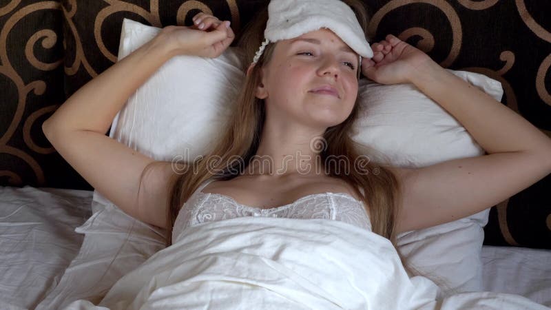 Sleepy Woman With Blindfolds On Eyes Stretching Stock Photo