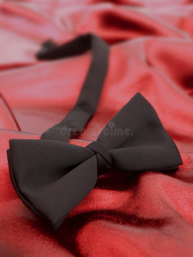 Black bow tie against red satin background. View my full portfolio for similar images. Black bow tie against red satin background. View my full portfolio for similar images.