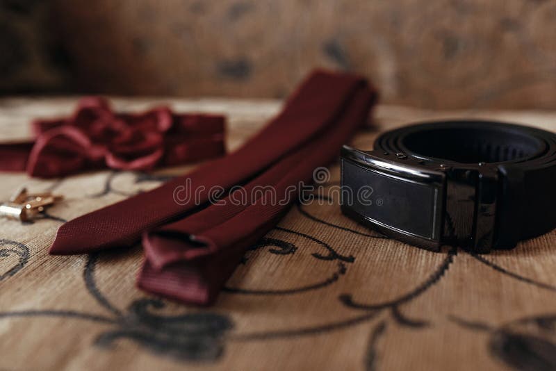 Laço e laço com correia e botão de punho vermelhos à moda na cama morn imagens de stock royalty free Laço e laço com correia e botão de punho vermelhos à moda na cama morn imagens de stock royalty free