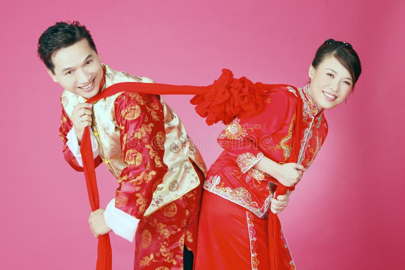 Beautifull couple wearing proudly traditional clothes polling a magic bond of marriage for eternity. Beautifull couple wearing proudly traditional clothes polling a magic bond of marriage for eternity