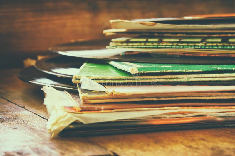 Records stack with record on top over wooden table. vintage filtered. Records stack with record on top over wooden table. vintage filtered.