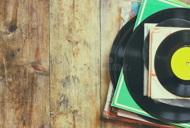 Records stack with record on top over wooden table. vintage filtered. Records stack with record on top over wooden table. vintage filtered.