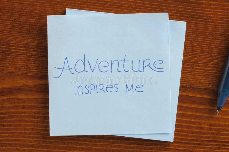 Le avventure mi ispirano, scritto su un biglietto immagini stock libere da diritti