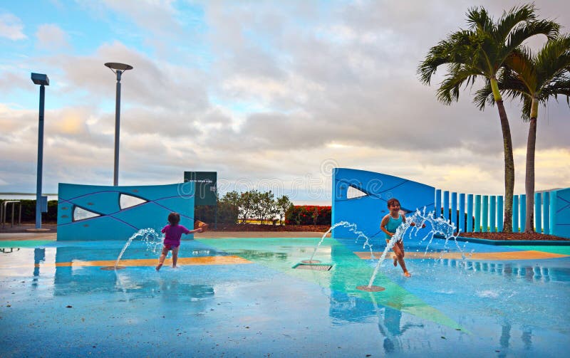 Le bambine che si divertono in acqua pubblica del lungomare dei cairn parcheggiano dentro immagine stock libera da diritti Le bambine che si divertono in acqua pubblica del lungomare dei cairn parcheggiano dentro immagine stock libera da diritti