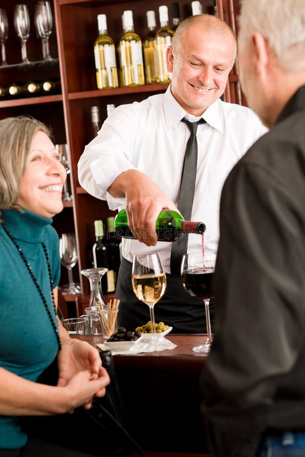 Le barman aîné de couples de bar de vin pleuvoir à torrents la glace images libres de droits Le barman aîné de couples de bar de vin pleuvoir à torrents la glace images libres de droits