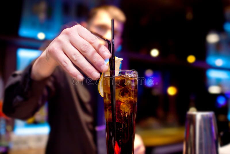 Le barman décore la tranche de verre de citron de boisson pétillante image libre de droits Le barman décore la tranche de verre de citron de boisson pétillante image libre de droits