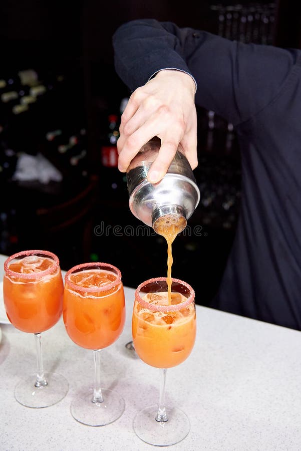 Le barman prépare les cocktails oranges photo libre de droits Le barman prépare les cocktails oranges photo libre de droits