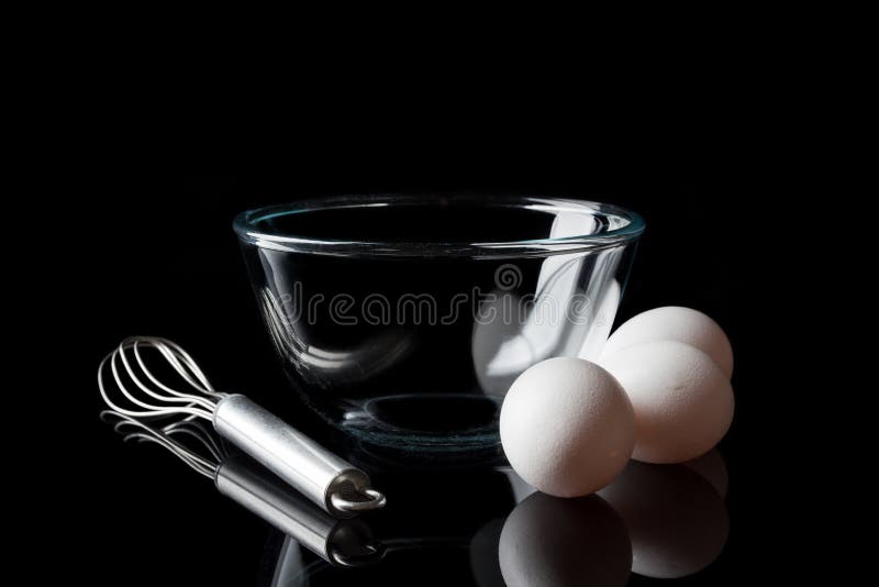 Le basette della ciotola di vetro eggs dal lato sul nero fotografia stock libera da diritti Le basette della ciotola di vetro eggs dal lato sul nero fotografia stock libera da diritti