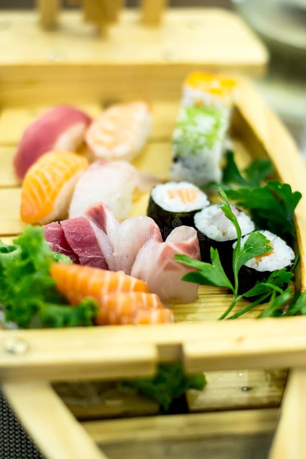 Le bateau en bois exquis a rempli avec différents types de morceaux de sushi et de poissons photo libre de droits Le bateau en bois exquis a rempli avec différents types de morceaux de sushi et de poissons photo libre de droits