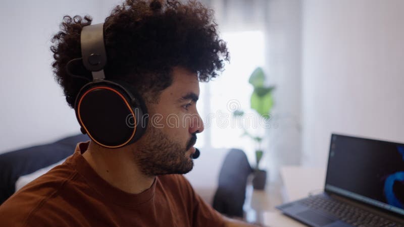 Le beau barbu travaille à la maison en parlant dans les écouteurs