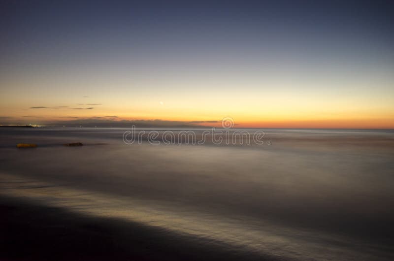 Le beau paysage de flambage de coucher du soleil en mer la Mer Caspienne et le ciel orange au-dessus de lui avec la réflexion d'o images stock Le beau paysage de flambage de coucher du soleil en mer la Mer Caspienne et le ciel orange au-dessus de lui avec la réflexion d'o images stock