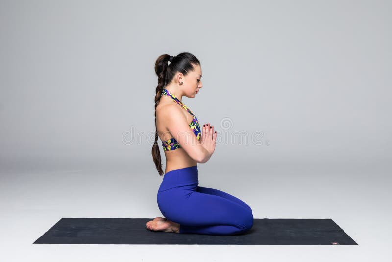 Le beau yoga de pratique en matière de femme de yoga pose sur le fond gris photo stock Le beau yoga de pratique en matière de femme de yoga pose sur le fond gris photo stock