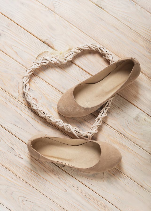 Le ` beige s de femmes chausse des ballerines sur le fond en bois image stock Le ` beige s de femmes chausse des ballerines sur le fond en bois image stock