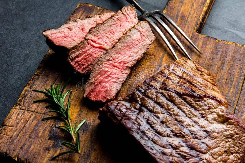 Le bifteck de boeuf rare moyen grillé coupé en tranches a servi sur le barbecue de conseil en bois, filet de boeuf de viande de B