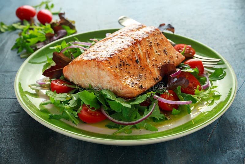Le bifteck saumoné cuit au four avec la tomate, l'oignon, mélange de vert laisse la salade dans un plat Nourriture saine images stock Le bifteck saumoné cuit au four avec la tomate, l'oignon, mélange de vert laisse la salade dans un plat Nourriture saine images stock