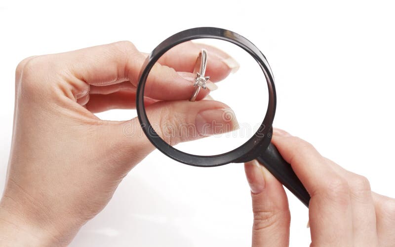 Le bijoutier de femme examinant la boucle de diamant avec magnifient images stock Le bijoutier de femme examinant la boucle de diamant avec magnifient images stock