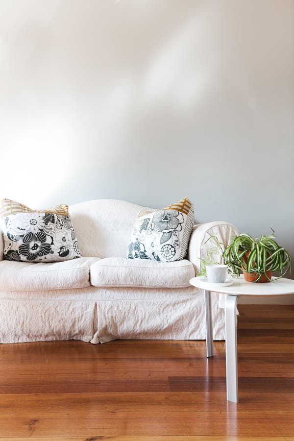 Le blanc a peint le mur gris avec le sofa blanc de style campagnard photos stock Le blanc a peint le mur gris avec le sofa blanc de style campagnard photos stock
