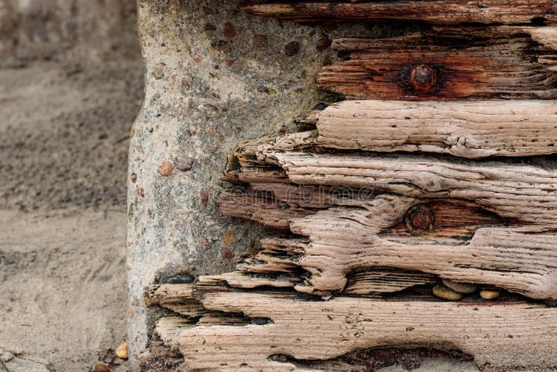 Le bois de flottage avec les boulons rouillés a placé contre un mur en pierre en béton, fond de grunge de vintage photos stock Le bois de flottage avec les boulons rouillés a placé contre un mur en pierre en béton, fond de grunge de vintage photos stock