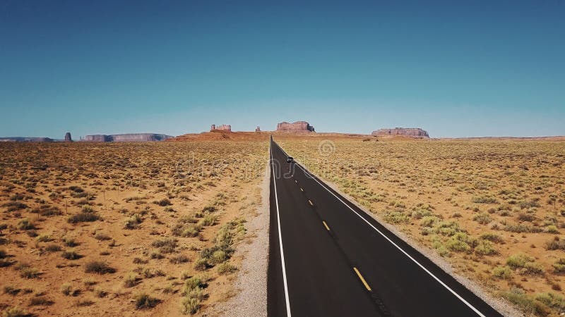 Le bourdon suit la voiture se déplaçant le long de la route américaine iconique de route de désert en vallée de monuments avec le