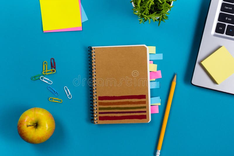 Le bureau de table de bureau avec l'ensemble d'approvisionnements colorés, bloc-notes vide blanc, tasse, stylo, PC, a chiffonné l photographie stock libre de droits Le bureau de table de bureau avec l'ensemble d'approvisionnements colorés, bloc-notes vide blanc, tasse, stylo, PC, a chiffonné l photographie stock libre de droits