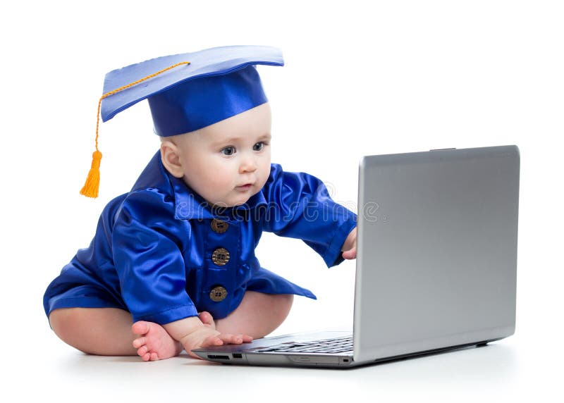 Le bébé dans la robe scolaire travaille sur l'ordinateur portable