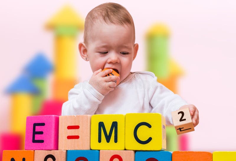 Genius baby with high IQ is playing with cubes and writing formulas. Genius baby with high IQ is playing with cubes and writing formulas.