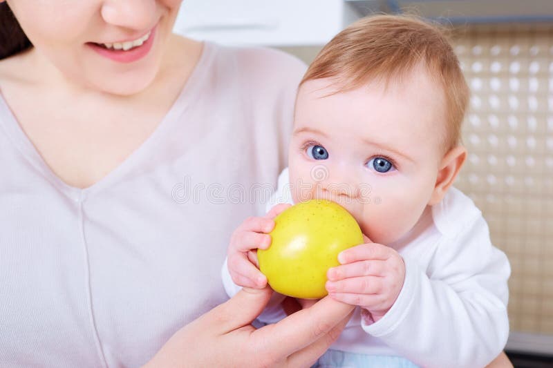 Le bébé mange la pomme jaune Enfant images libres de droits