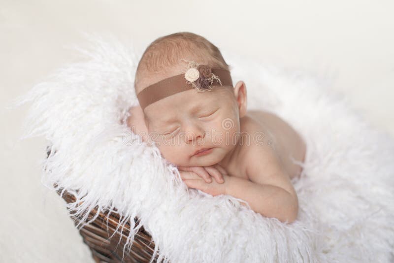 le bébé nouveau-né dort dans un panier brun sur un plaid blanc image stock le bébé nouveau-né dort dans un panier brun sur un plaid blanc image stock