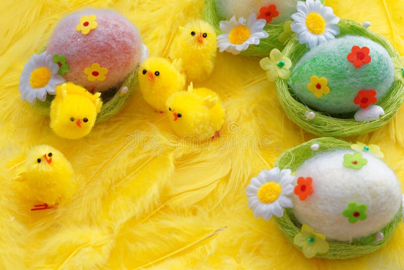 Le bébé Pâques jaune joue des poussins et des oeufs sur un fond des plumes Carte de voeux de fête photo libre de droits Le bébé Pâques jaune joue des poussins et des oeufs sur un fond des plumes Carte de voeux de fête photo libre de droits