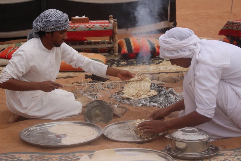 Le bédouin préparent le pain à un camp de désert en sables de Wahiba en Oman photographie stock libre de droits Le bédouin préparent le pain à un camp de désert en sables de Wahiba en Oman photographie stock libre de droits