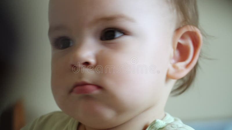 Le c? t? de b? b? a tir? le portrait en gros plan, enfant en bas? ge concentr? s? rieux,? coutant la m? re banque de vidéos