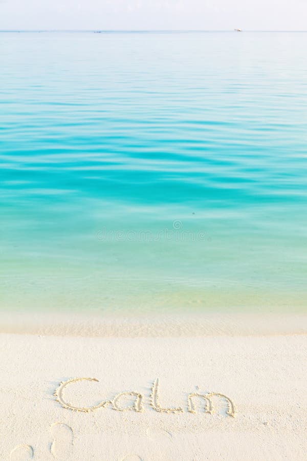 Le calme de Word écrit dans le sable sur une plage avec du Ba de mer de matin image libre de droits Le calme de Word écrit dans le sable sur une plage avec du Ba de mer de matin image libre de droits