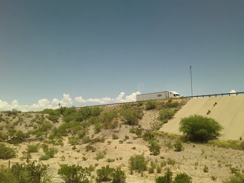 Le camion passe au-dessus d'un passage supérieur avec des nuages semblant couler derrière du train photographie stock Le camion passe au-dessus d'un passage supérieur avec des nuages semblant couler derrière du train photographie stock