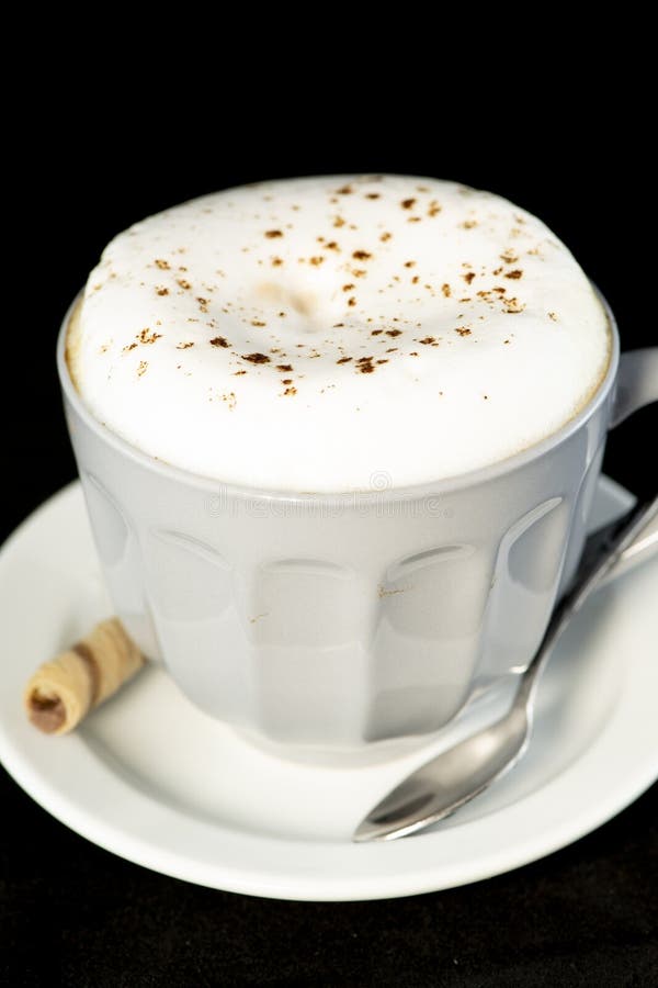 Le cappuccino délicieux a servi avec le petit pain de gaufrette de noisette de chocolat image libre de droits Le cappuccino délicieux a servi avec le petit pain de gaufrette de noisette de chocolat image libre de droits