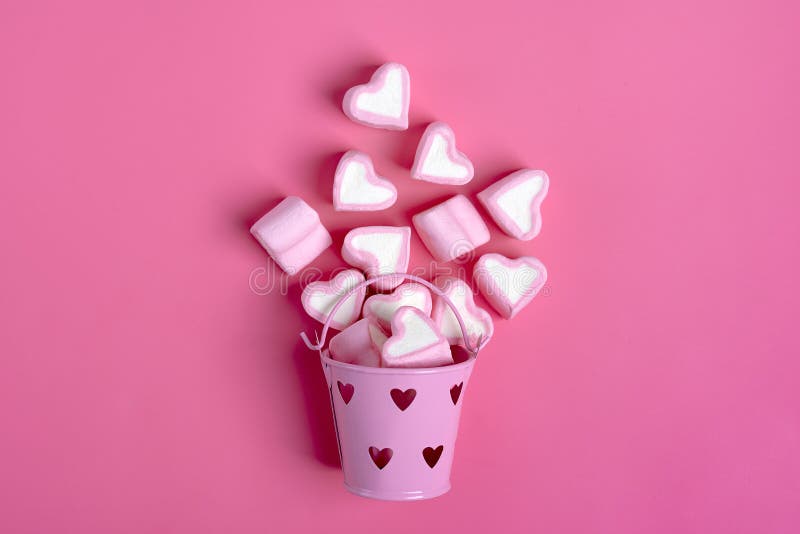 Le caramelle gommosa e molle e le caramelle a forma di del cuore hanno straripato un bucketon rosa del ferro un il San Valentino fotografia stock libera da diritti Le caramelle gommosa e molle e le caramelle a forma di del cuore hanno straripato un bucketon rosa del ferro un il San Valentino fotografia stock libera da diritti