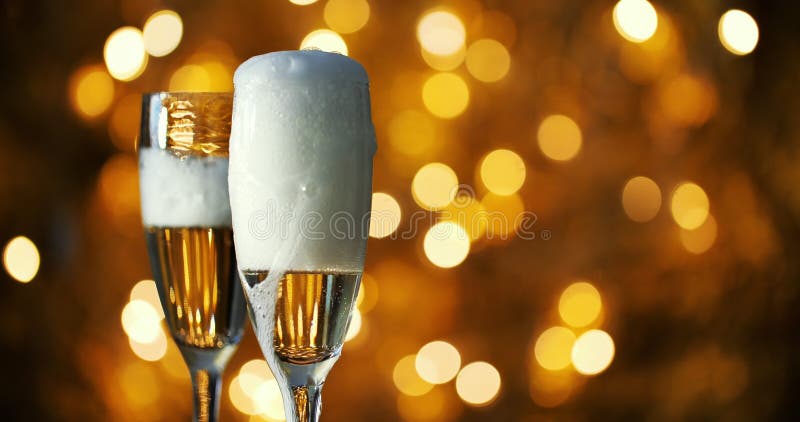 Le Champagne est versé dans des verres sur fond de guirlandes du Nouvel An
