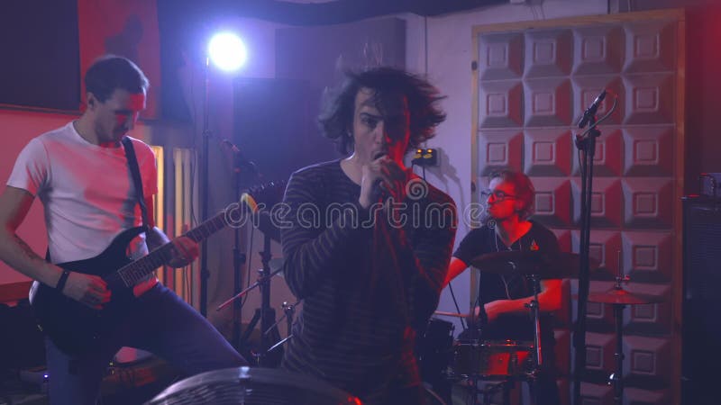 Le chanteur principal du groupe de rock chante émotionnellement dans le microphone. banque de vidéos